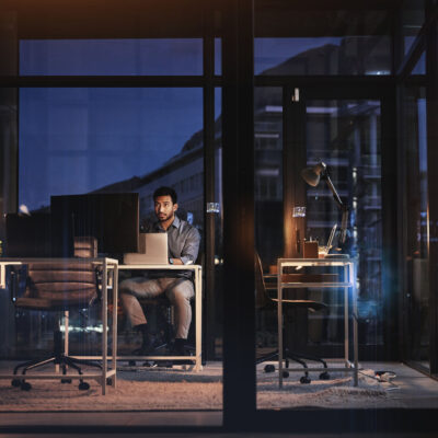 Image of a man in a futuristic office using AI on multiple screens