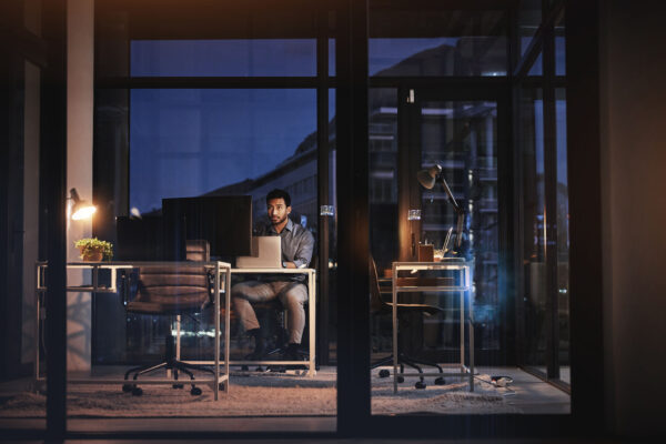Image of a man in a futuristic office using AI on multiple screens